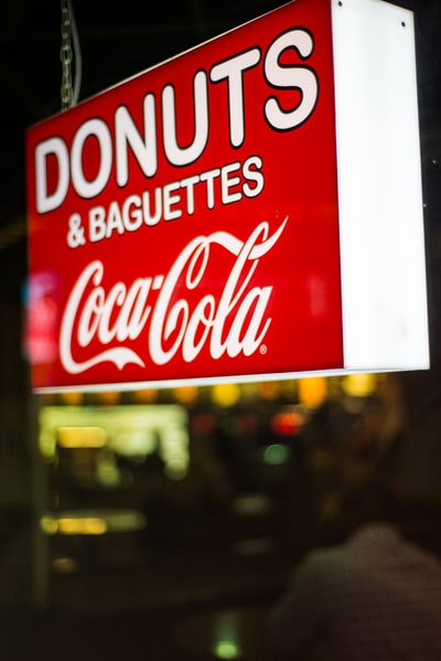 近距离拍摄甜甜圈和法式面包可口可乐标牌